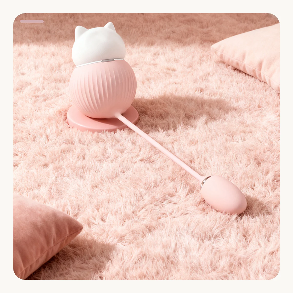 Pink Kitty Duo vibrator styled on a soft pink textile surface