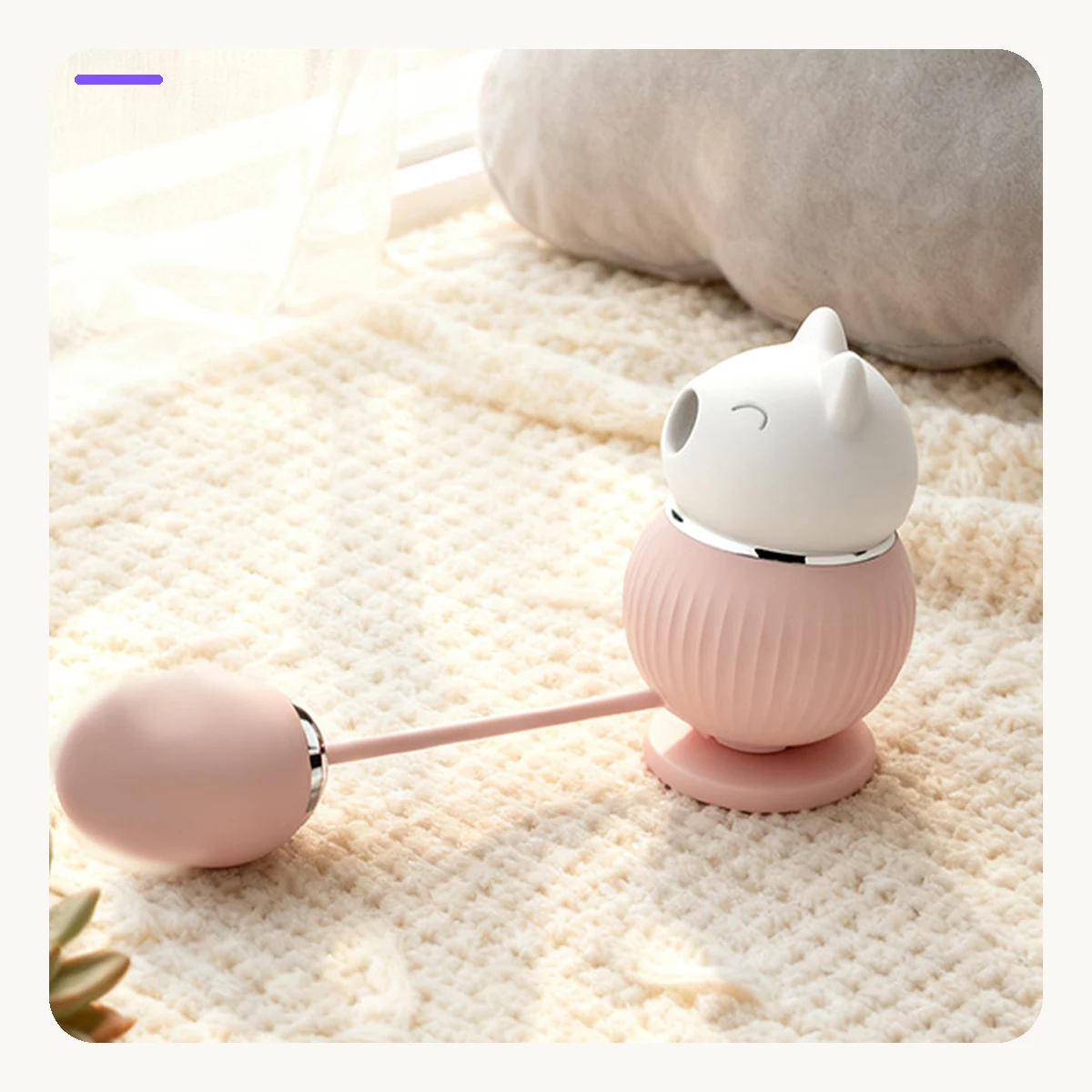 Pink Kitty Duo vibrator arranged in a warm cream lifestyle scene